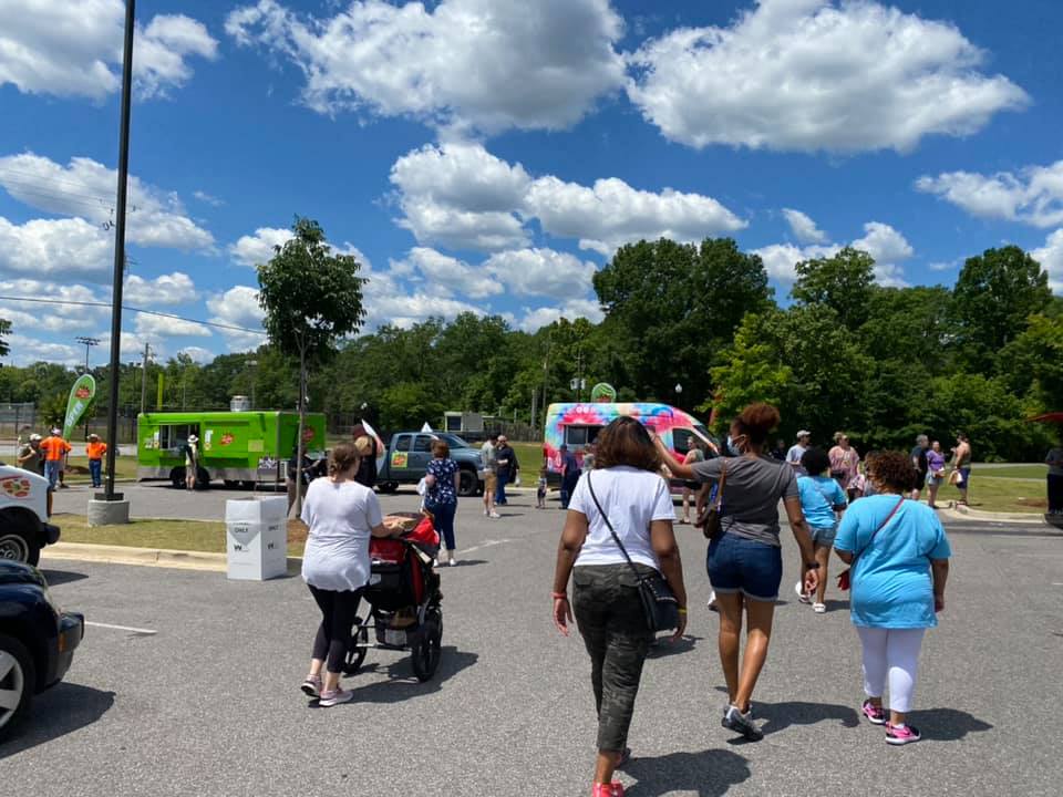 people buying food from food trucks on a sunny day