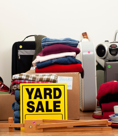 A collection of yard sale items is shown, along with a sign that reads, 