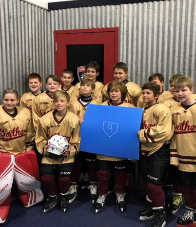 A group of youth hockey players dressed in yellow  uniforms.